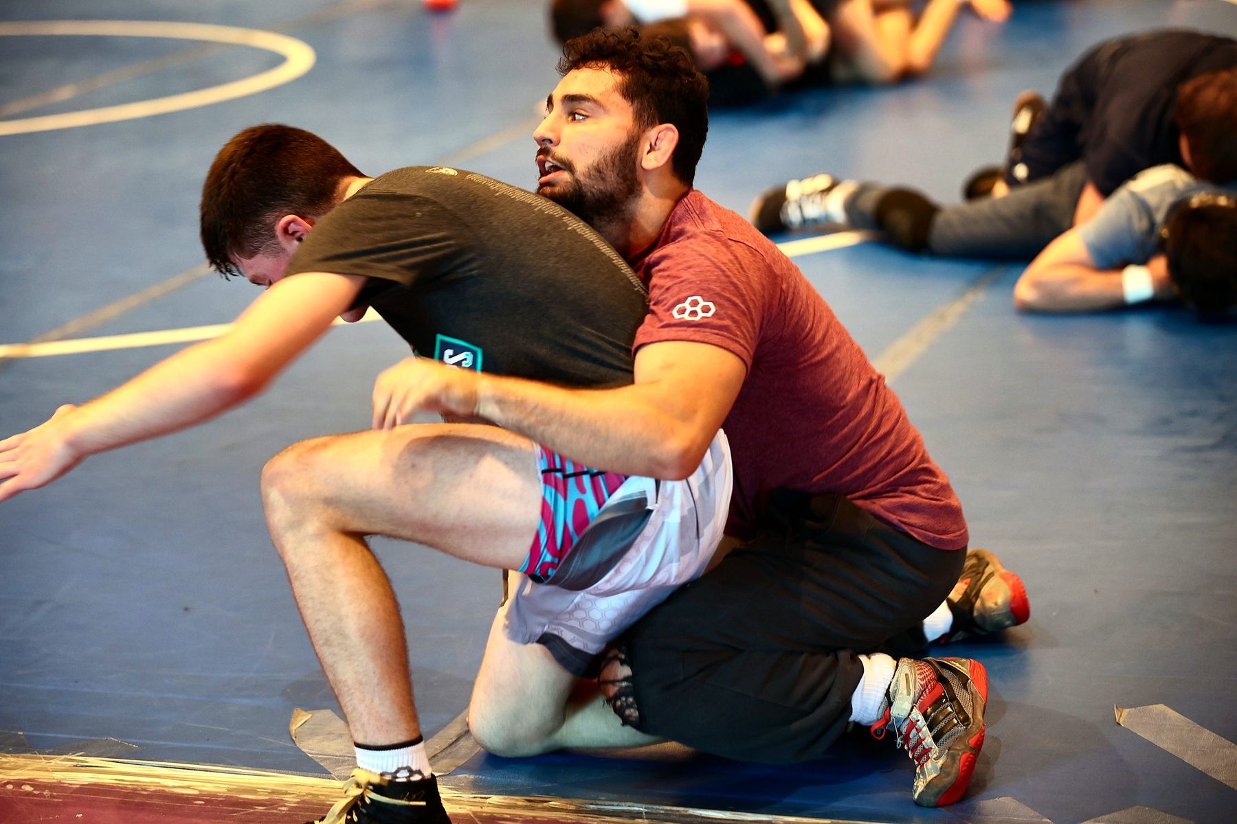 Two wrestlers drilling a takedown at Ken Chertow Gold Medal Training Camp