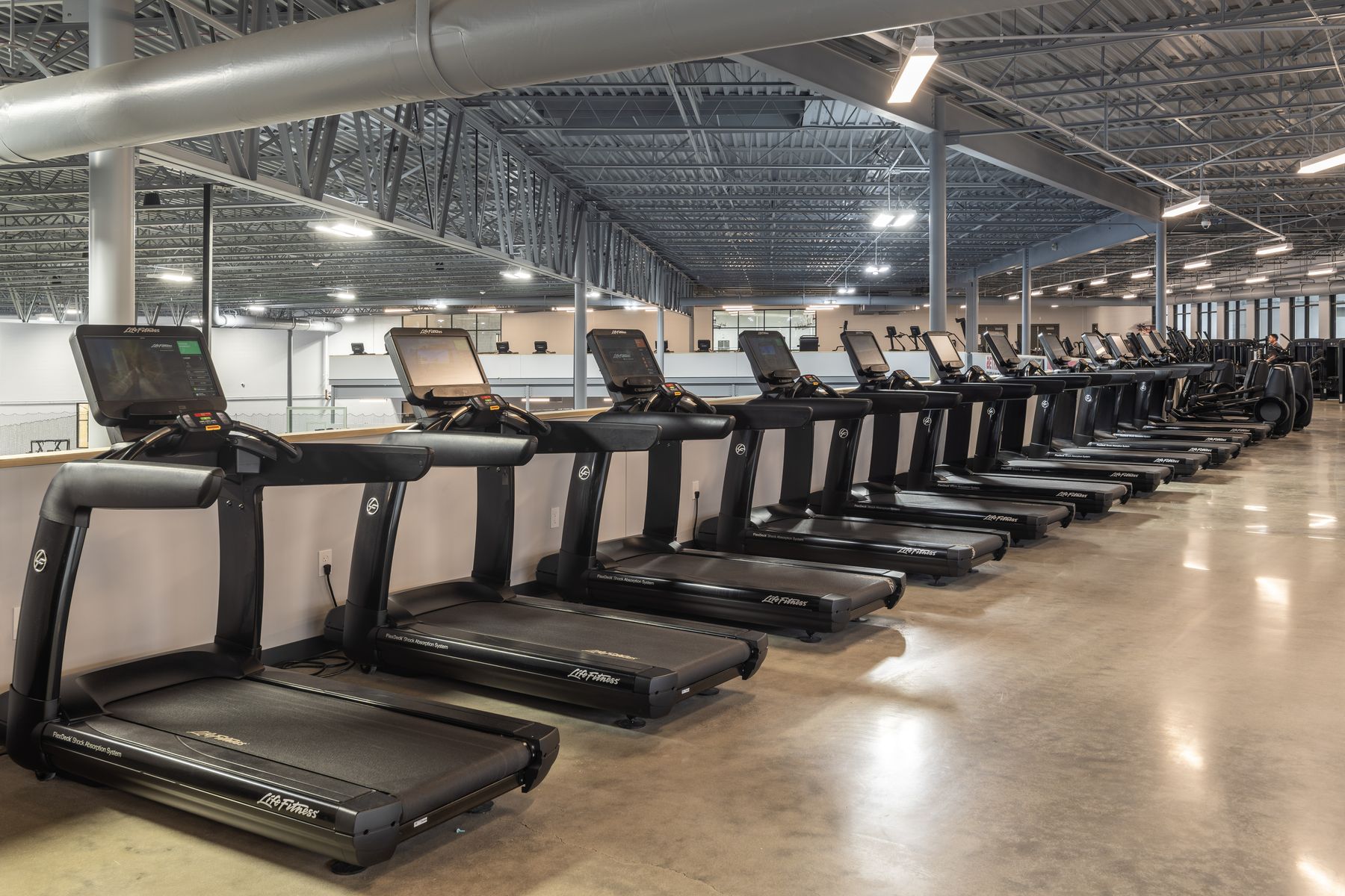 A row of treadmills beside indoor turf in the Champion Mill fitness center, Ken Chertow's Ohio camp venue