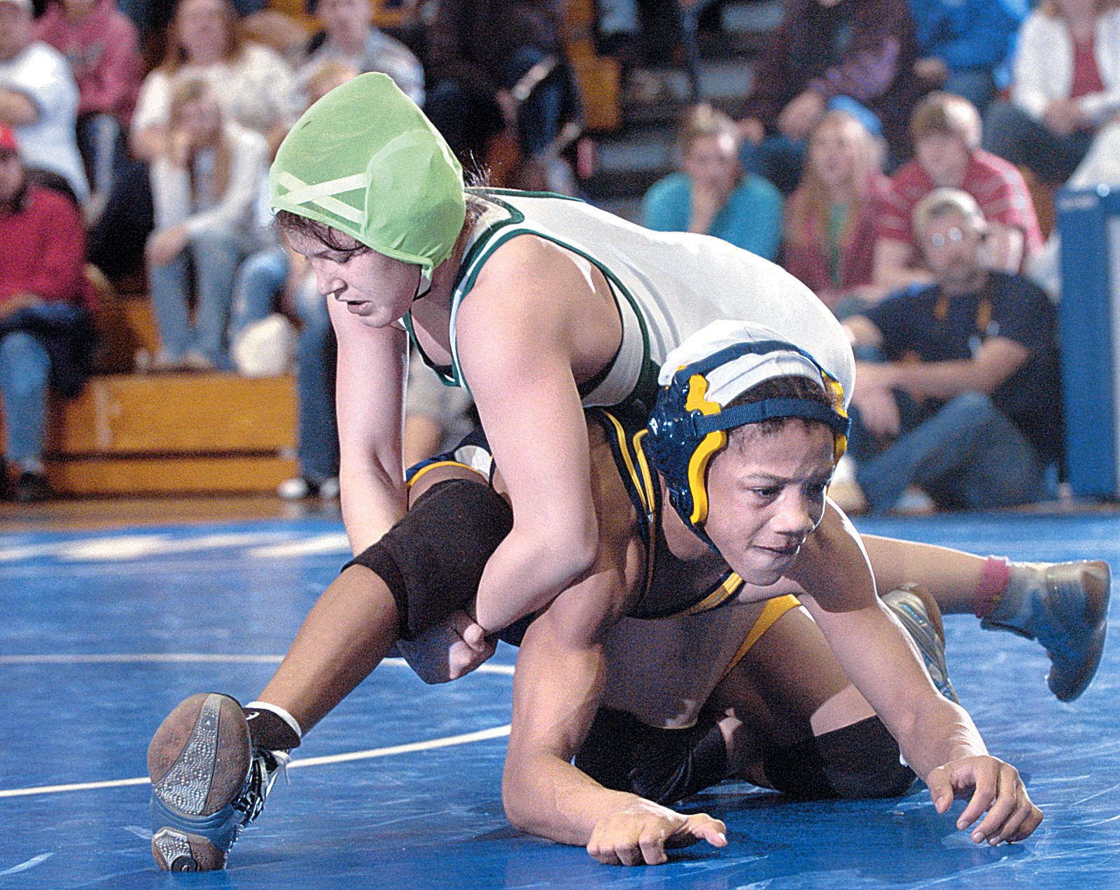 Nicole Woody in green headgear, on top of a Severna Park wrestler during a 2006 high school match for Arundel