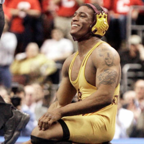 Anthony Robles kneeling on the mat and smiling, in an Arizona State singlet and headgear, Ken Chertow wrestling camp coach