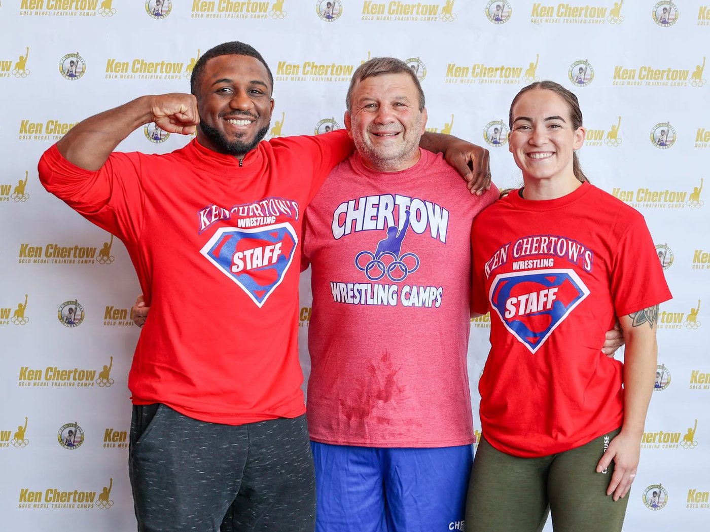 Ken Chertow between Stump Wagner and Alexia Wagner, camp staff in red shirts, at Ken Chertow's summer wrestling camp
