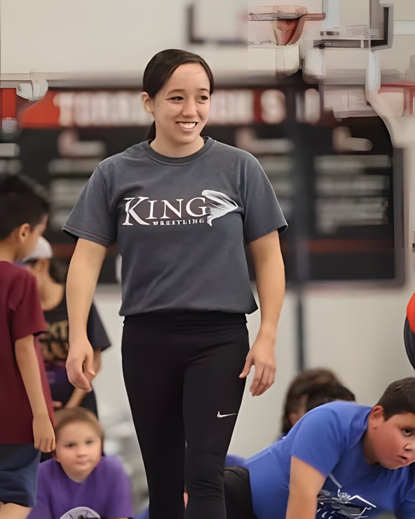 Marina Doi smiling as she walks across the mat at a youth clinic