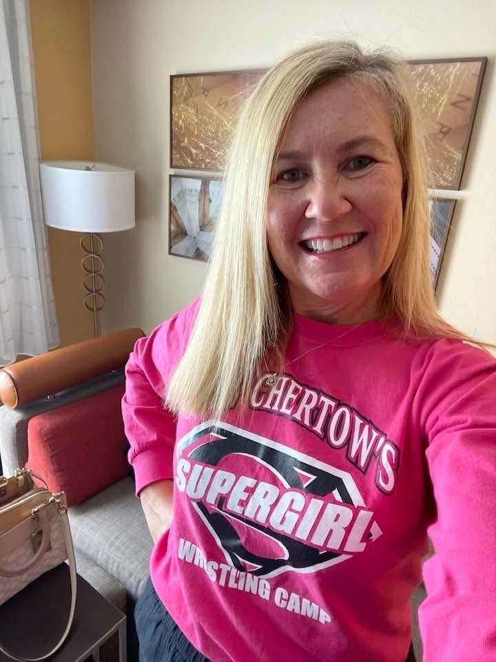 Beth Chertow smiling in a pink Chertow's SuperGirl Wrestling Camp sweatshirt
