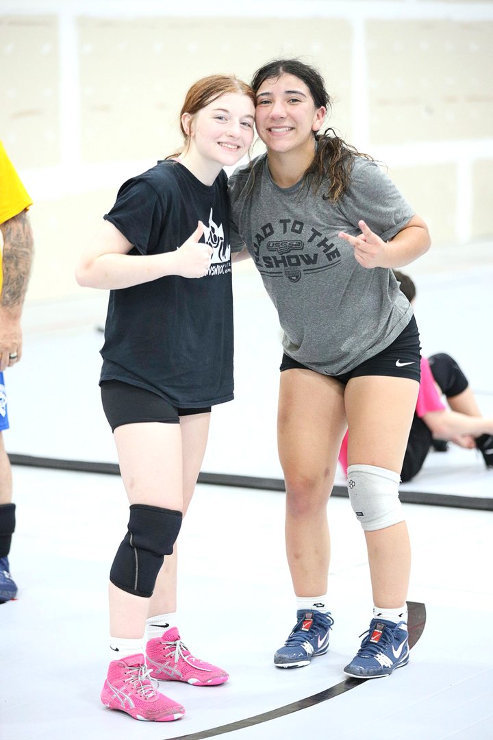 Two SuperGirl campers giving a thumbs up on the mat